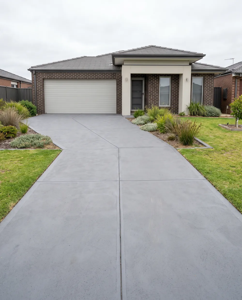 New broom finish grey concrete driveway after