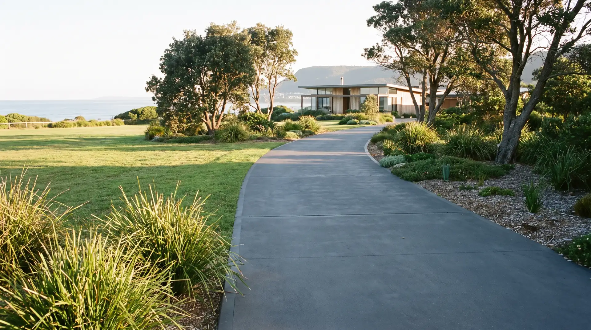 Concrete pathway curving alongside a modern home